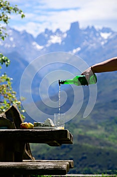 Pouring from high height of natural Asturian cider made fromÂ fermented apples, Asturian cabrales cow blue cheese with view on